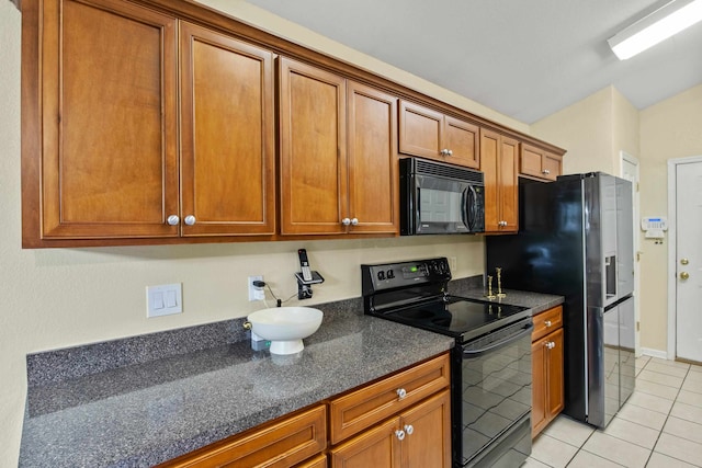 3224 Lord Murphy Trl, Tallahassee, FL 32309 - kitchen with brown cabinetry, light tile patterned flooring, black appliances, and dark stone counters