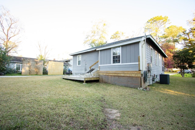 back of house with central AC unit, a yard, and a wooden deck