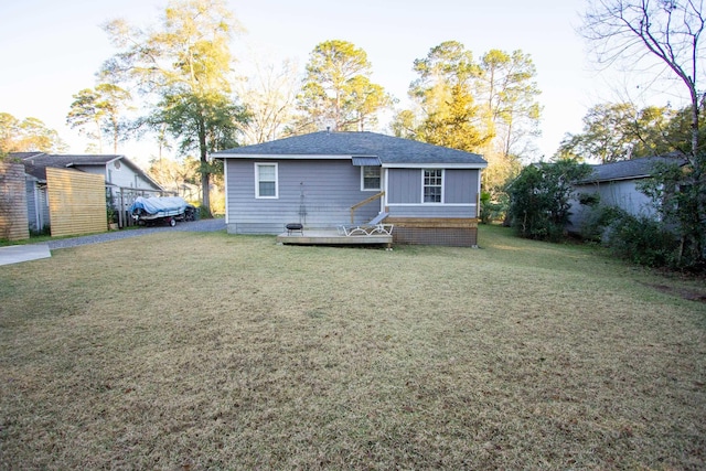 back of property featuring a deck and a lawn