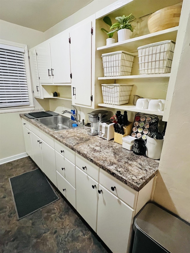 kitchen featuring sink, white cabinets, and black stovetop