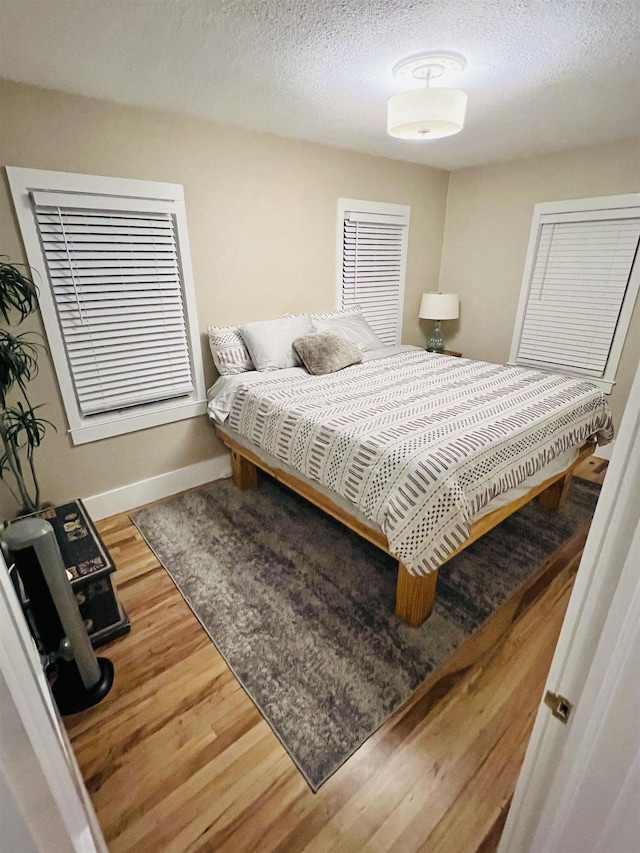 bedroom featuring hardwood / wood-style flooring and a textured ceiling