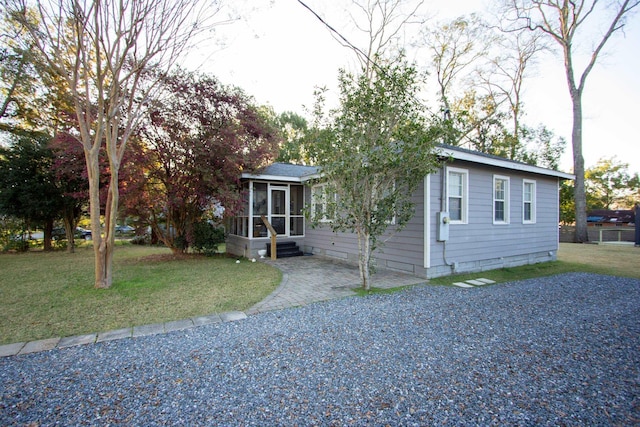 view of front facade with a sunroom and a front lawn