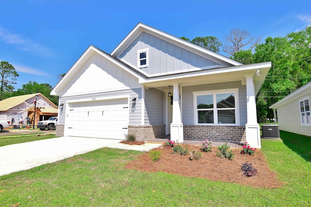 craftsman-style home featuring central air condition unit, a garage, a front lawn, and a porch