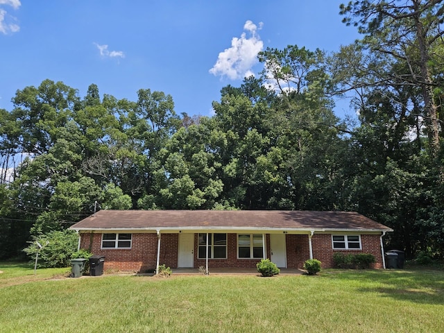 ranch-style house featuring covered porch and a front lawn