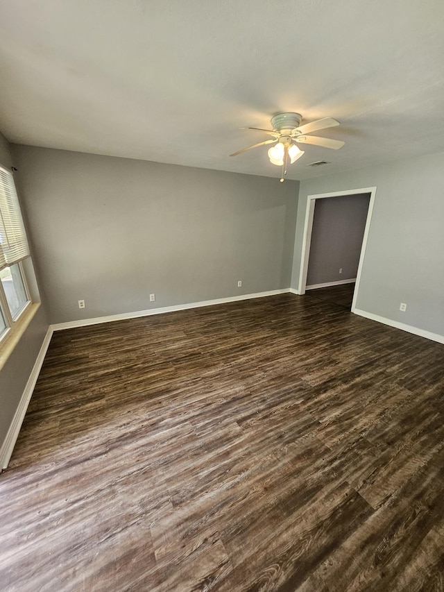 empty room featuring dark hardwood / wood-style flooring and ceiling fan