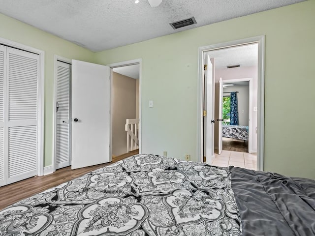 2271 Green Timbers Trl Unit B, Tallahassee, FL 32304 - bedroom with two closets, a textured ceiling, and wood finished floors