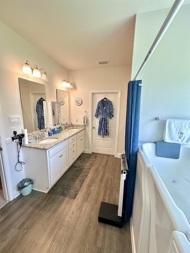 63 Windsor Way, Crawfordville, FL 32327 - bathroom featuring a bathtub, wood finished floors, and double vanity