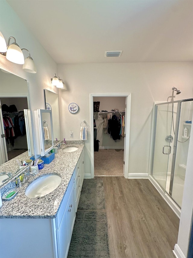 63 Windsor Way, Crawfordville, FL 32327 - bathroom with a spacious closet, double vanity, wood finished floors, and a shower stall