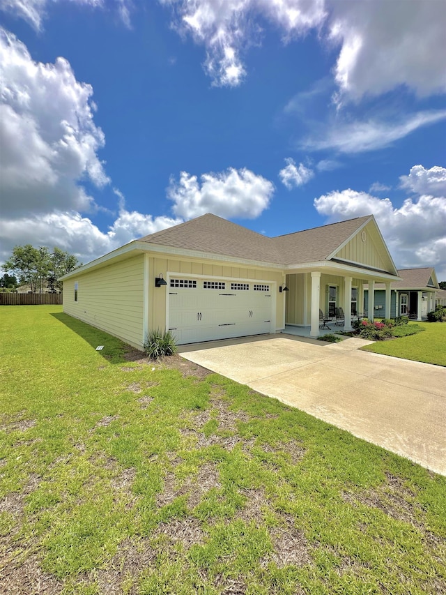 63 Windsor Way, Crawfordville, FL 32327 - view of front of house with a garage, board and batten siding, a front lawn, driveway, and covered porch
