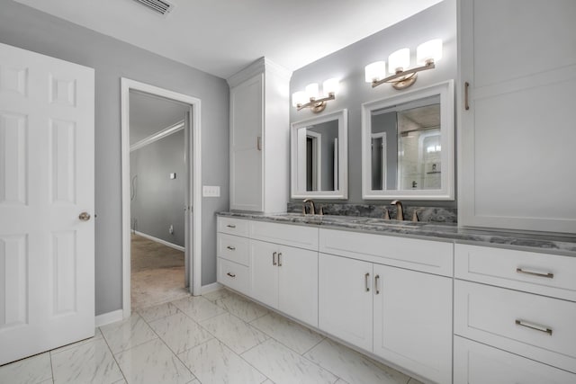 bathroom featuring a sink, double vanity, marble finish floor, baseboards, and a shower with door