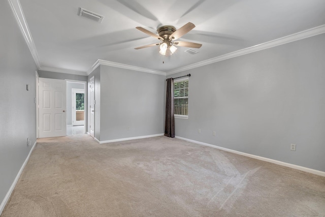empty room featuring crown molding, ceiling fan, light carpet, and visible vents