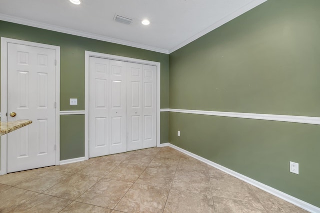 unfurnished bedroom with baseboards, light tile patterned floors, visible vents, ornamental molding, and a closet