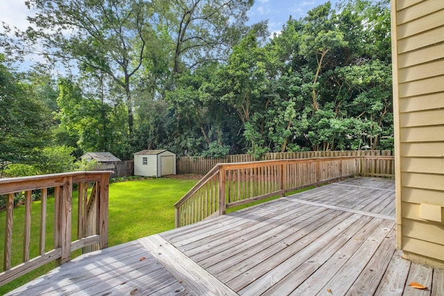 deck featuring a lawn, a fenced backyard, an outbuilding, and a storage shed