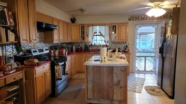 kitchen with stainless steel appliances, backsplash, light tile patterned floors, sink, and ceiling fan