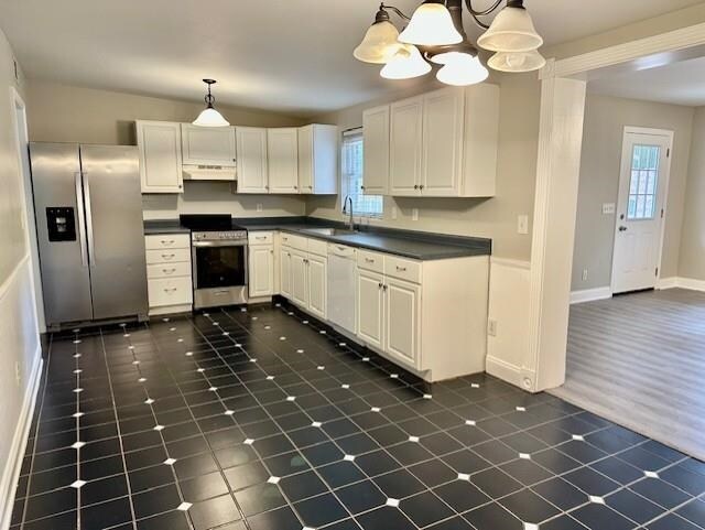 kitchen with sink, decorative light fixtures, white cabinets, and appliances with stainless steel finishes