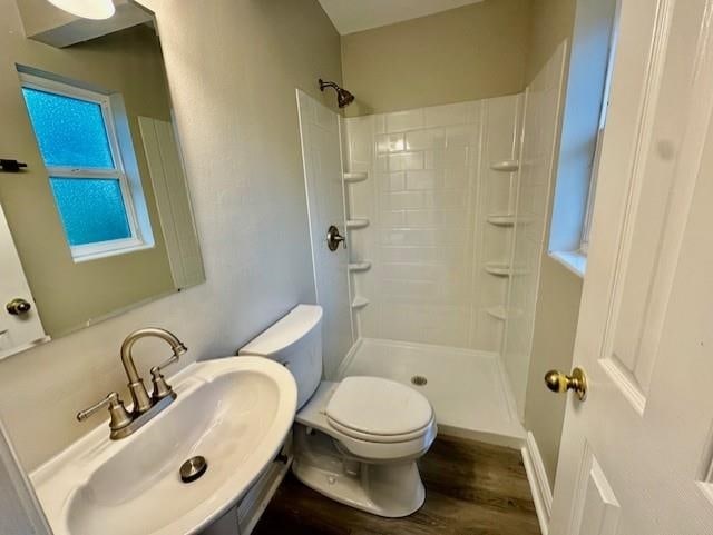 bathroom with sink, hardwood / wood-style floors, toilet, and walk in shower