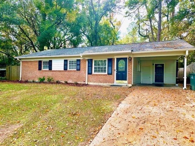 ranch-style home featuring a carport and a front lawn