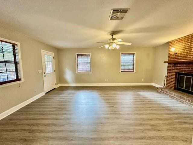 unfurnished living room featuring ceiling fan, hardwood / wood-style floors, and a fireplace