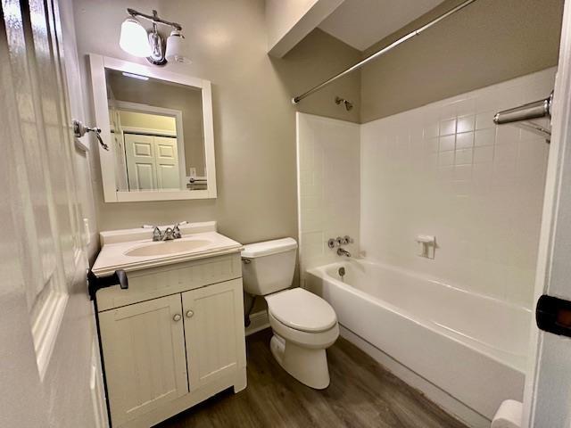 full bathroom featuring vanity, toilet, tiled shower / bath combo, and hardwood / wood-style floors