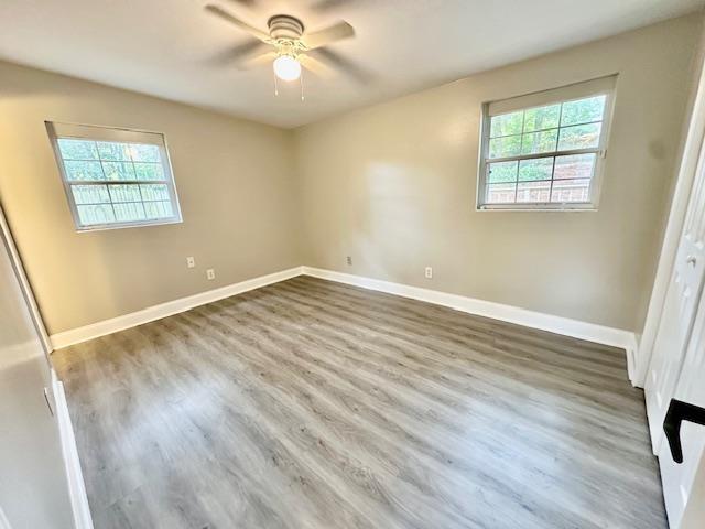 unfurnished bedroom featuring hardwood / wood-style floors, ceiling fan, and a closet