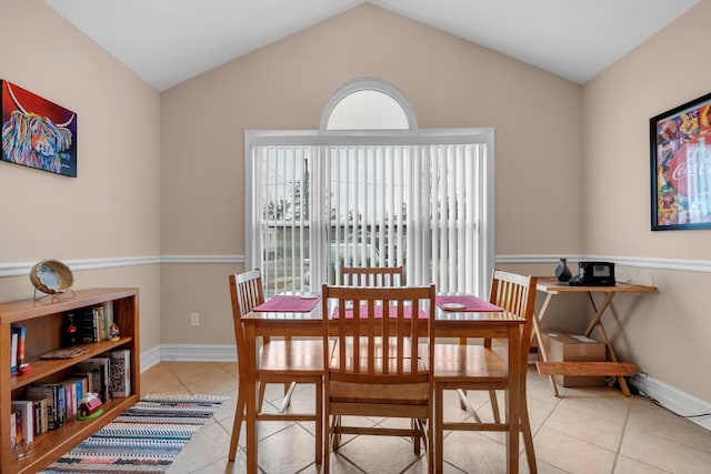 dining area featuring vaulted ceiling and light tile patterned floors