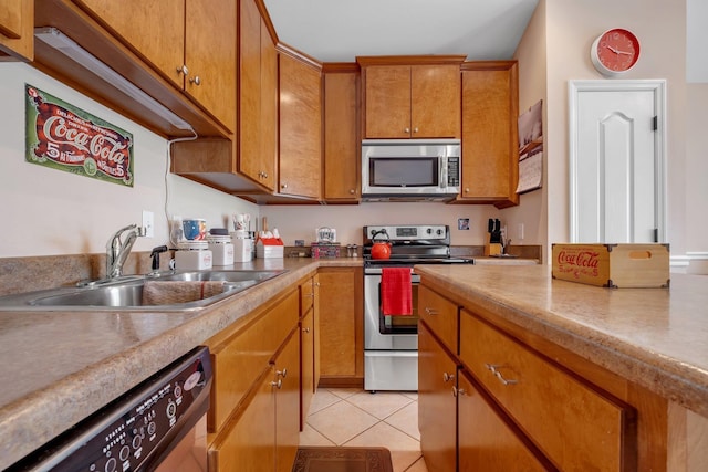 kitchen with stainless steel appliances, sink, and light tile patterned floors