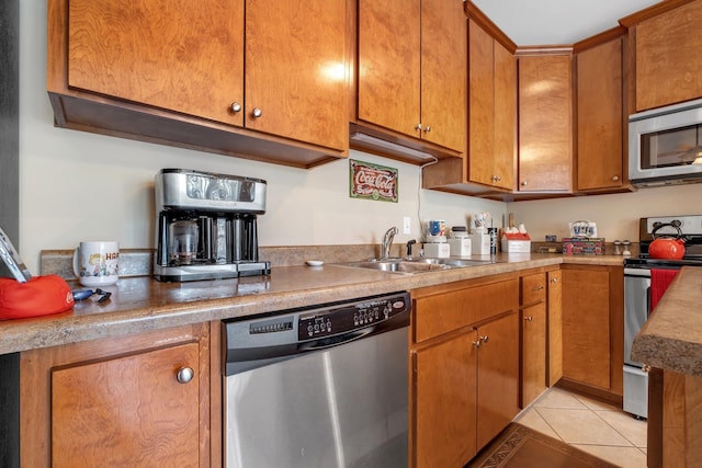 kitchen featuring sink, light tile patterned floors, and appliances with stainless steel finishes