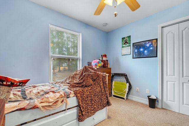 bedroom featuring light carpet, a closet, and ceiling fan