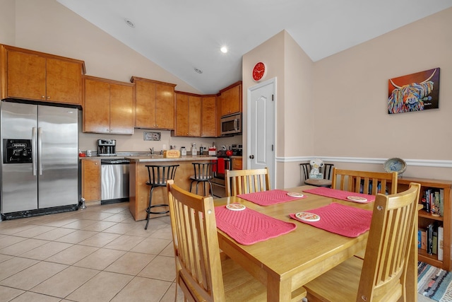 dining space featuring light tile patterned flooring and lofted ceiling