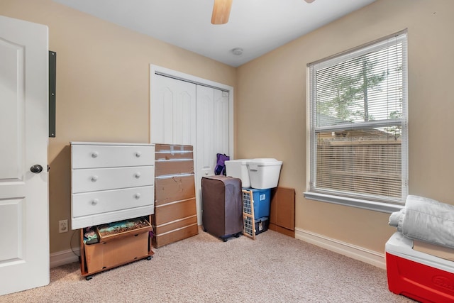 interior space with light colored carpet, ceiling fan, and a closet