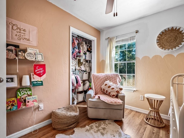 living area featuring hardwood / wood-style floors and ceiling fan