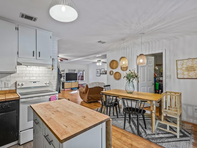 kitchen with pendant lighting, white range with electric cooktop, a center island, and light hardwood / wood-style flooring