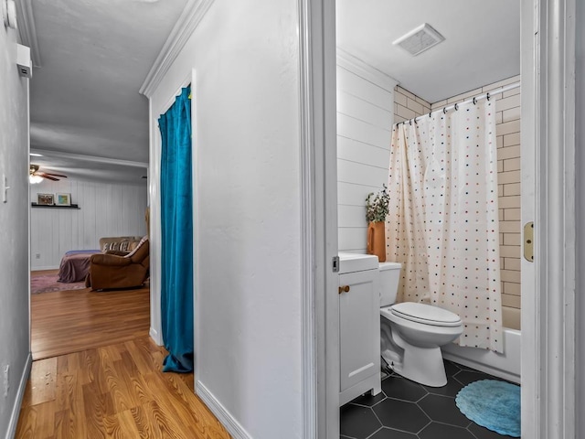 bathroom with hardwood / wood-style flooring, shower / tub combo, ceiling fan, and toilet