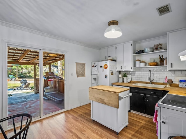 kitchen featuring white cabinetry, white appliances, wooden counters, and sink