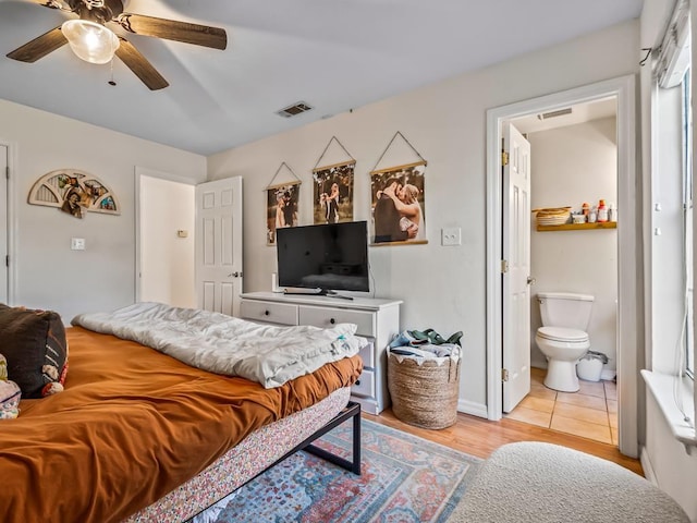 bedroom featuring light tile patterned flooring, ceiling fan, and ensuite bath