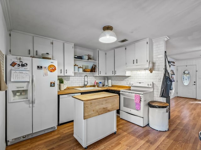 kitchen with sink, backsplash, a center island, light hardwood / wood-style floors, and white appliances