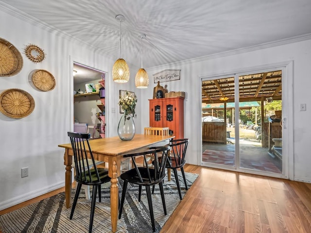 dining space with crown molding, washer / dryer, and light hardwood / wood-style floors