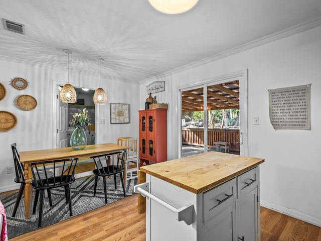 kitchen with pendant lighting, crown molding, gray cabinetry, and light wood-type flooring