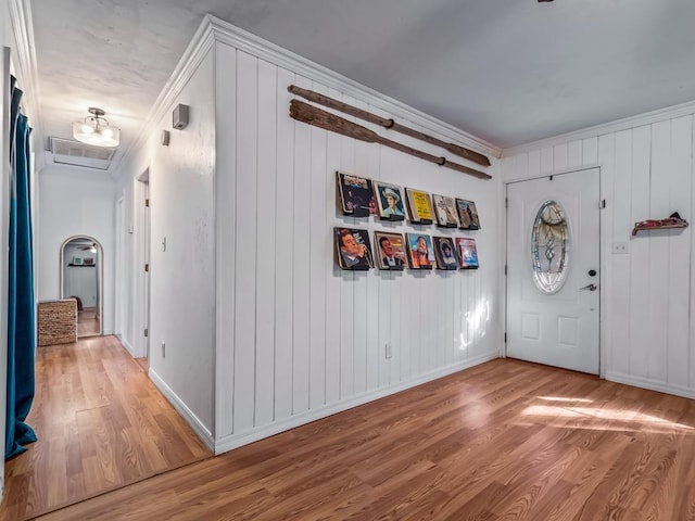 foyer entrance with hardwood / wood-style floors and crown molding