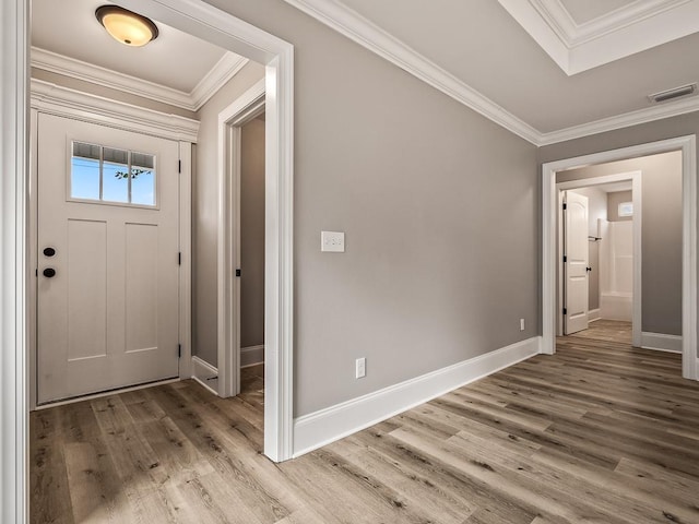 foyer featuring ornamental molding and light hardwood / wood-style flooring