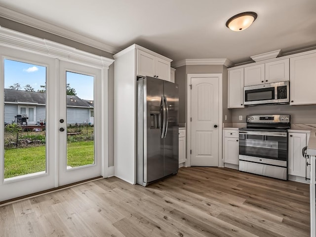 kitchen featuring white cabinetry, crown molding, light hardwood / wood-style floors, and appliances with stainless steel finishes