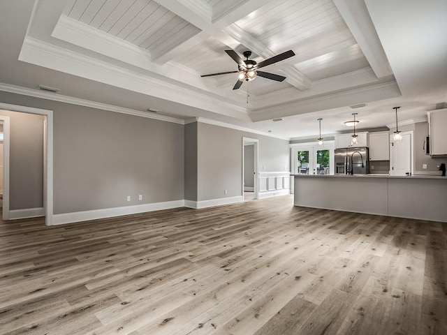 unfurnished living room with ceiling fan, beam ceiling, coffered ceiling, ornamental molding, and light hardwood / wood-style floors