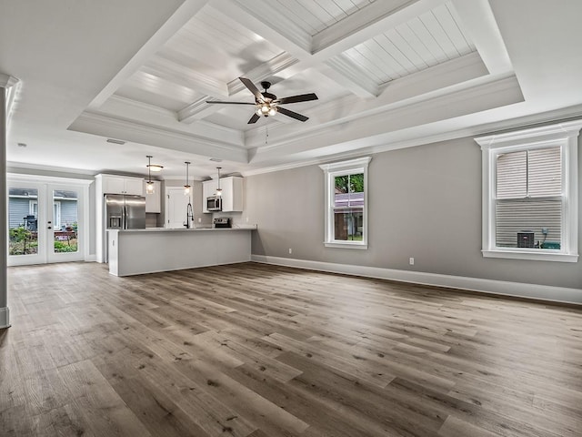 unfurnished living room featuring coffered ceiling, hardwood / wood-style floors, ornamental molding, and french doors