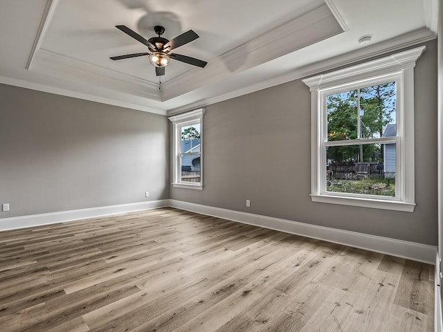 unfurnished room featuring crown molding, ceiling fan, a tray ceiling, and light hardwood / wood-style floors