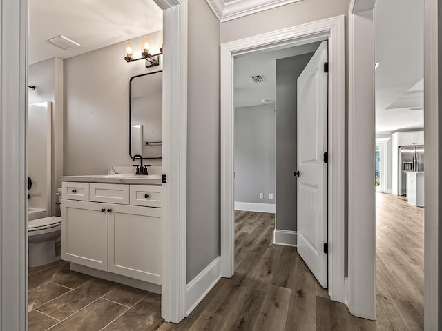 full bathroom with crown molding, shower / bath combination, hardwood / wood-style floors, vanity, and toilet