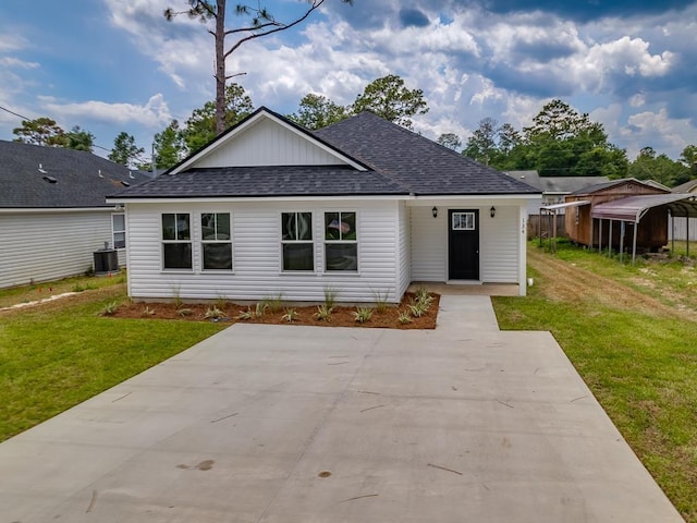 view of front of house featuring a front lawn, a carport, and central air condition unit