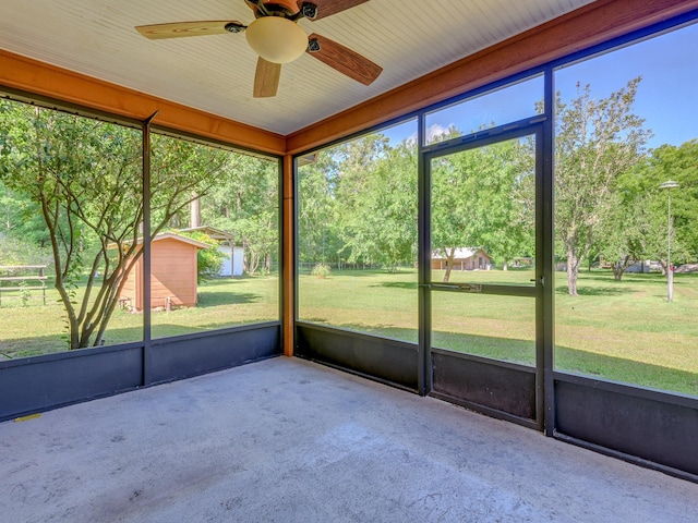 unfurnished sunroom featuring ceiling fan