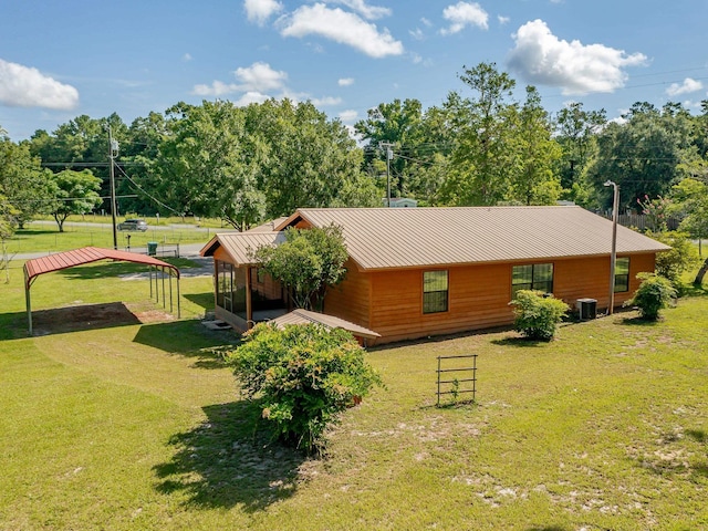 rear view of house with metal roof and a lawn