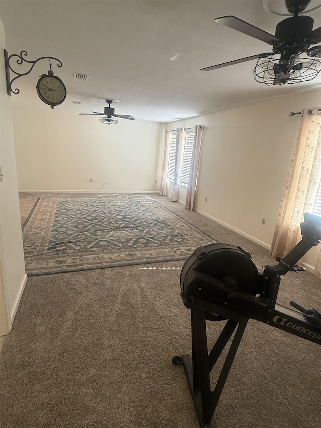 interior space featuring carpet floors, visible vents, ceiling fan, and baseboards