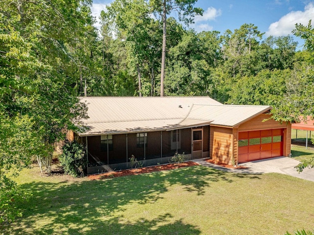 view of front of home featuring a garage, a sunroom, a front lawn, and concrete driveway